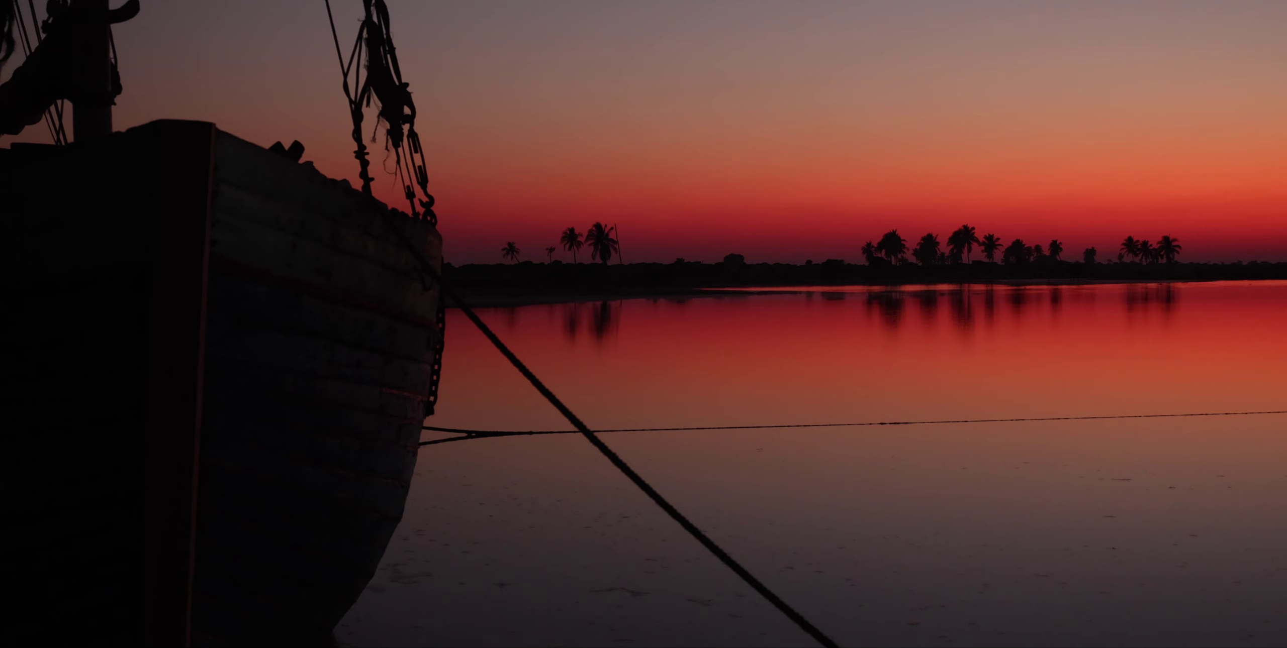 Coucher de soleil rouge-violet sur le lagon de Belo sur Mer, boutre amarré en silhouette