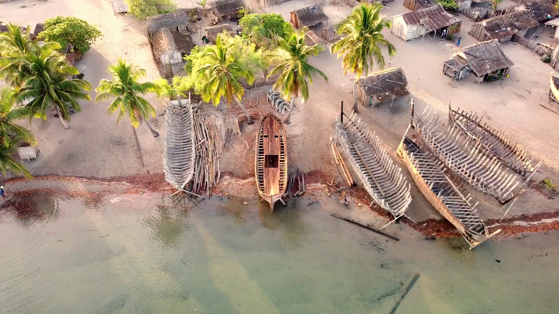 Vue aérienne des chantiers navals de Belo — squelettes de bateaux en construction, palmiers